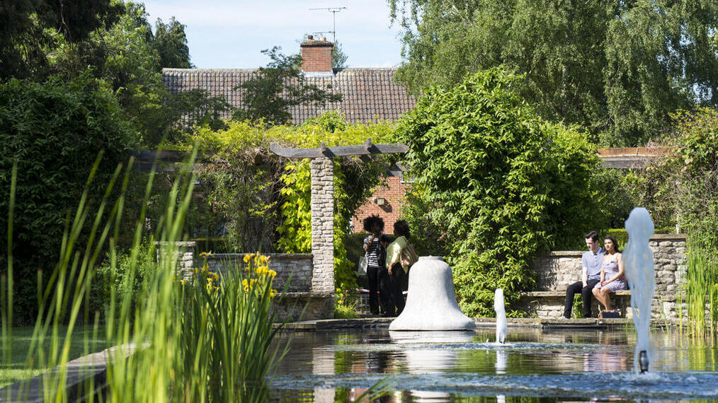 Una pareja sentada junto a una fuente en el Jardín Botánico de Leicester