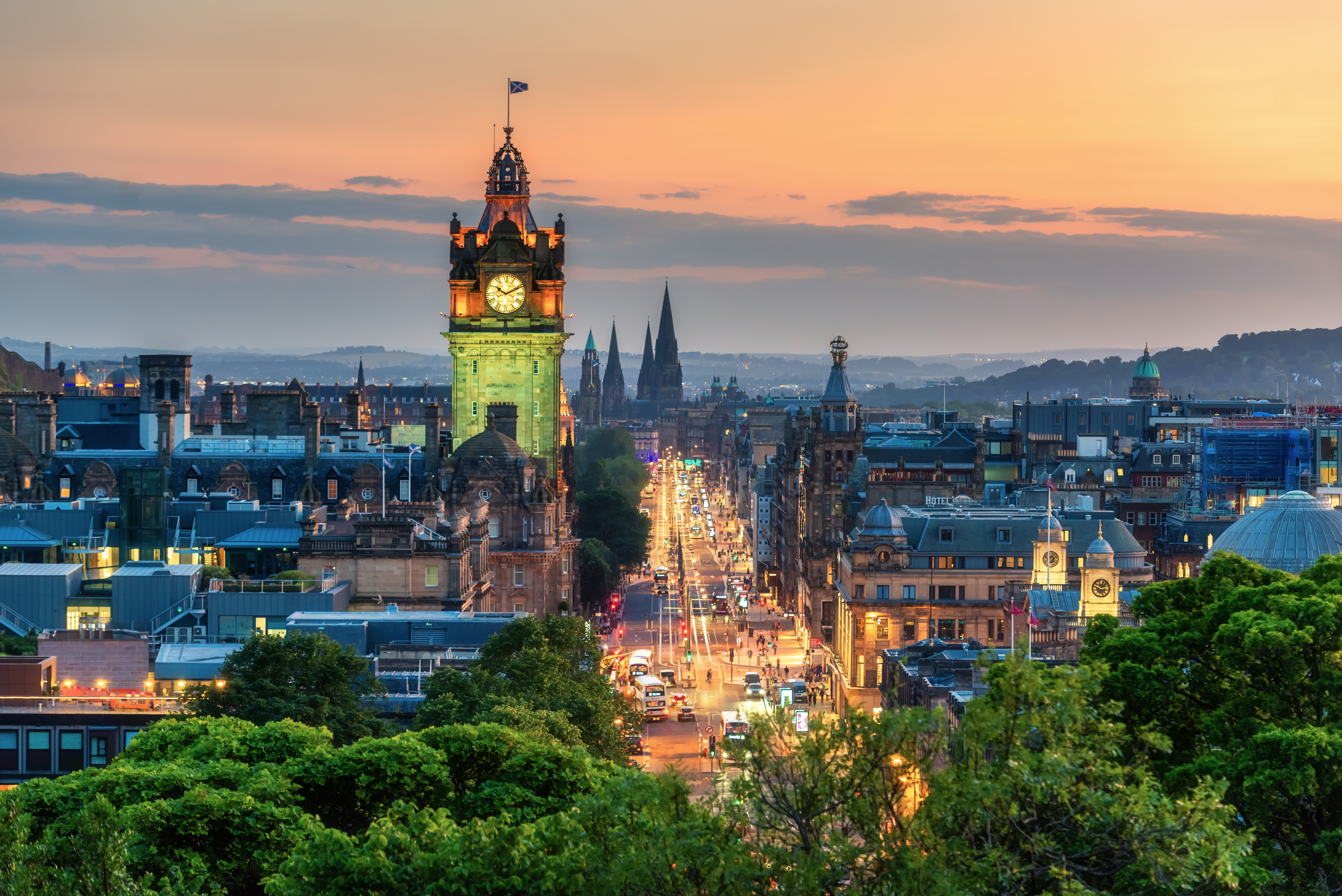 A clock tower at sunset in a busy city
