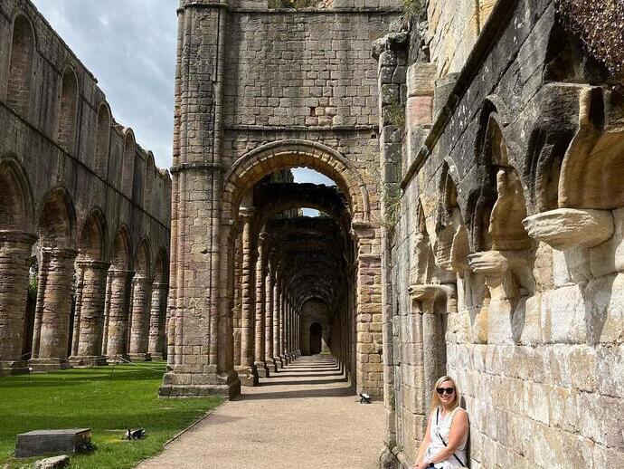Una signora fuori dalla Fountain Abbey allo Studley Royal Park