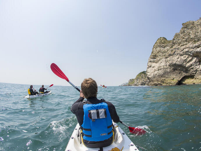People kayaking along the shores of coastline