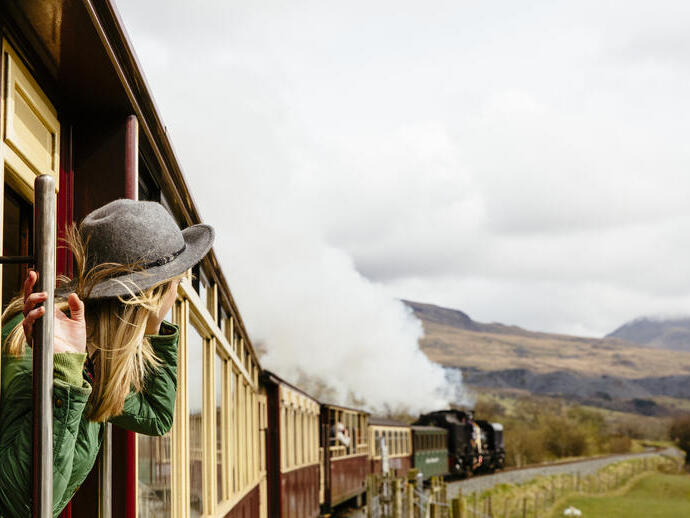 Donna che guarda fuori dal finestrino di un treno tradizionale