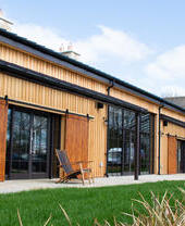 An exterior view of the wooden clad visitor centre at a distillery.