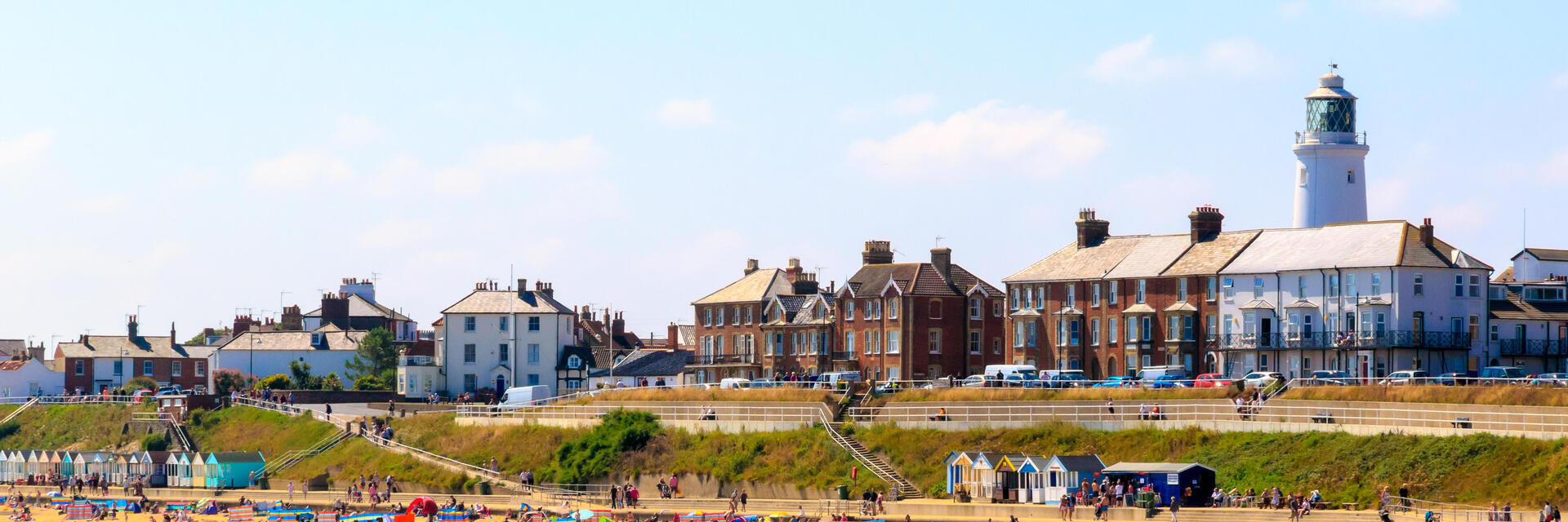 Beach with seaside cottages, beach huts and a lighthouse