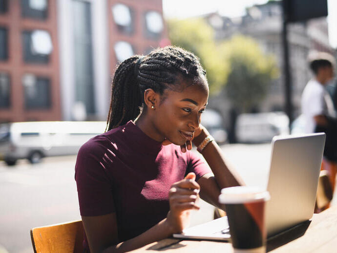 Woman using a laptop at an outdoor café