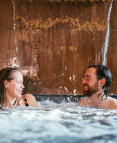 Una pareja en una piscina como parte de un tratamiento de spa en Wave Garden Spa