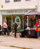 People outside shop with sign reading: Cambridge Distillery Shop