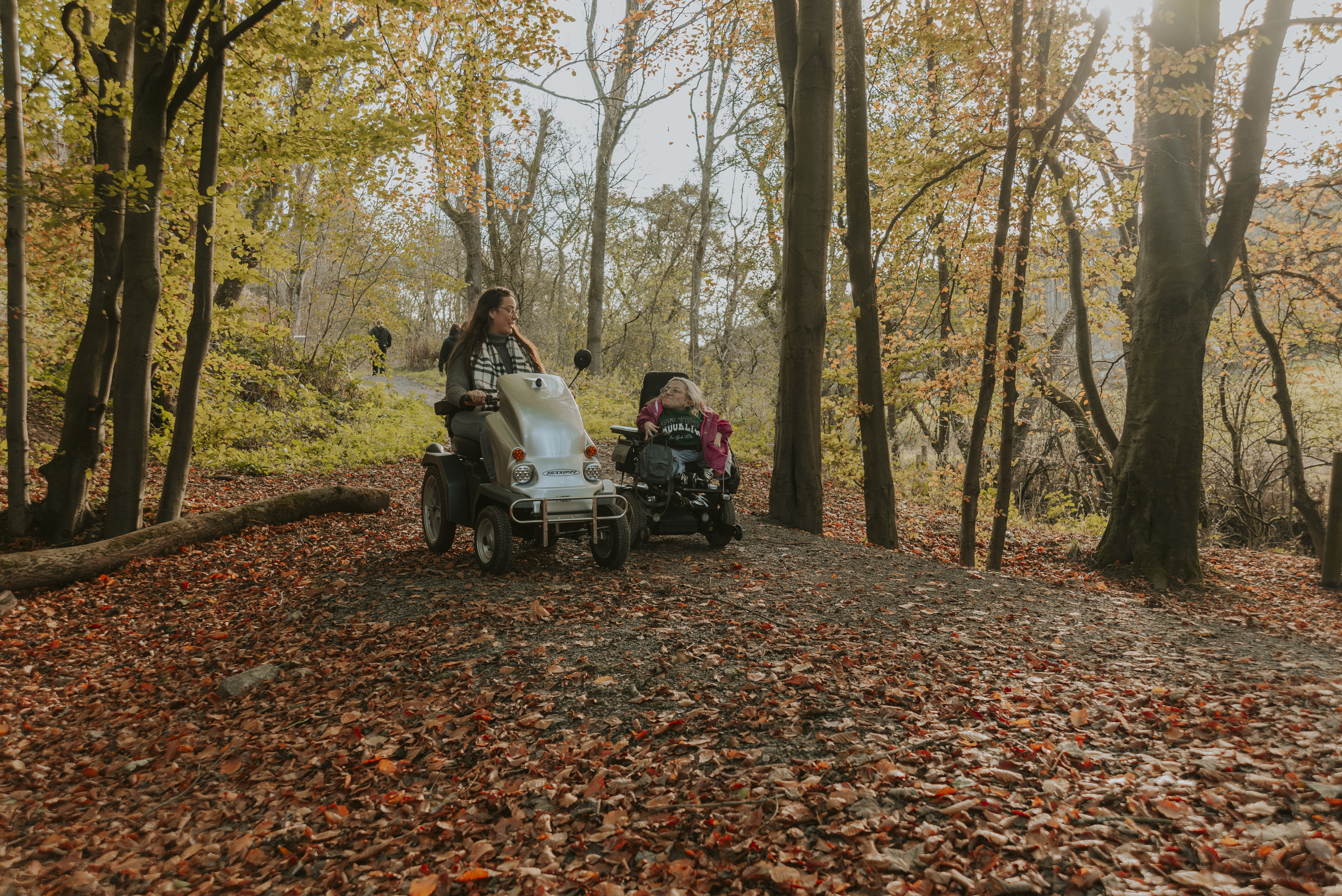 Deux femmes utilisant des scooters électriques dans une forêt