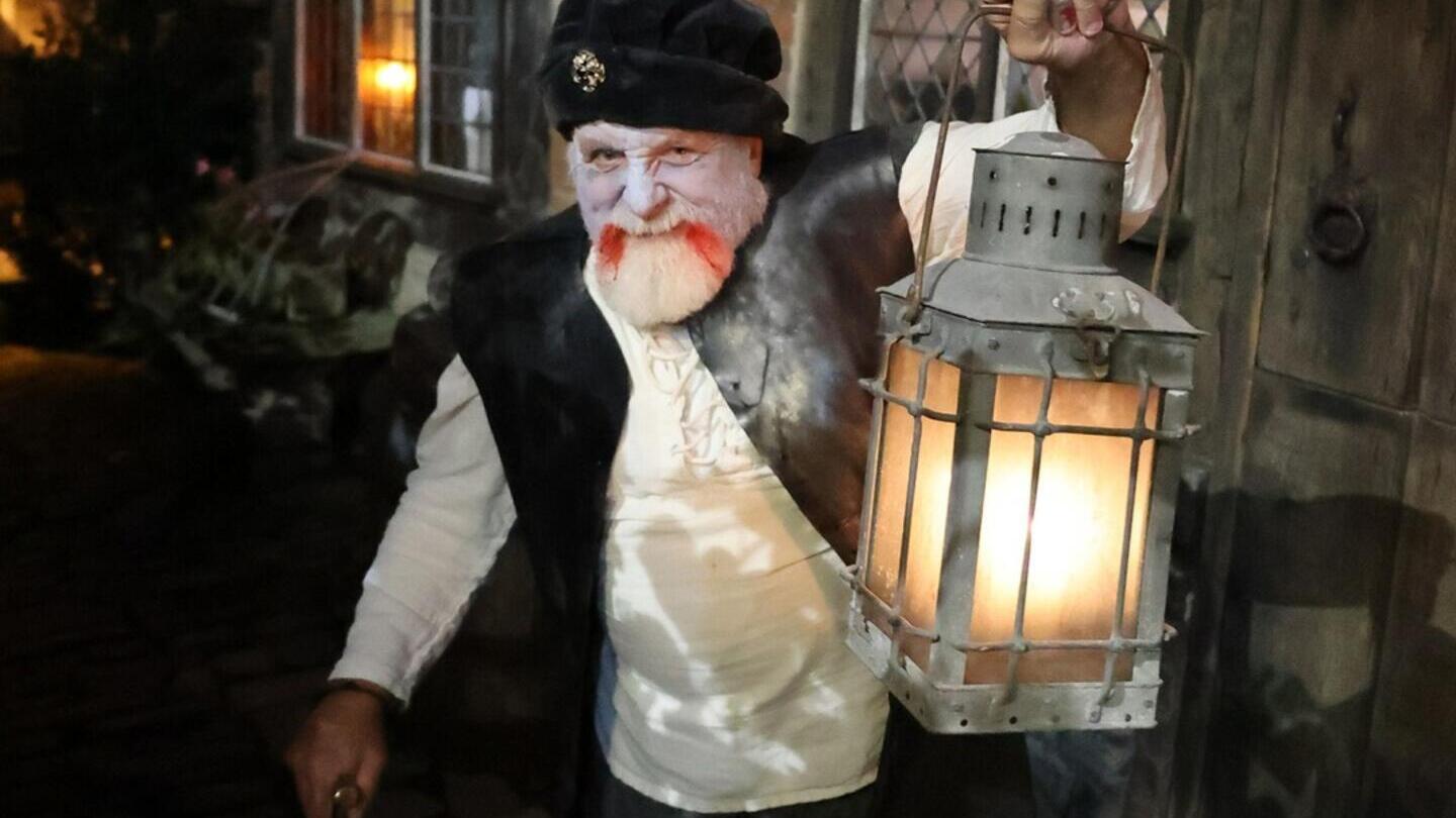 Un homme tenant une lanterne au Tudor World Museum
