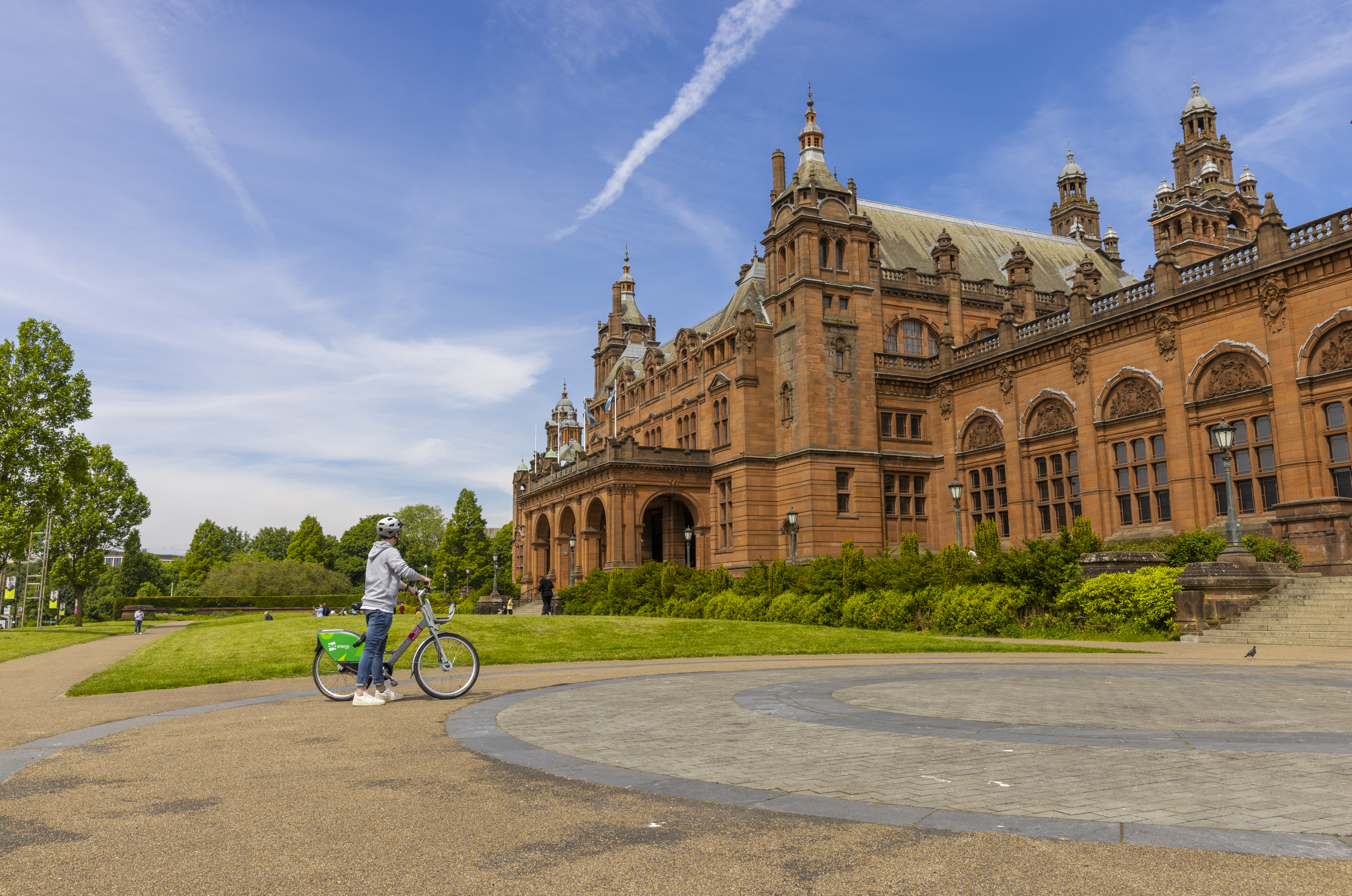 A cyclist parked out the front of an ornate Art Gallery and Museum.