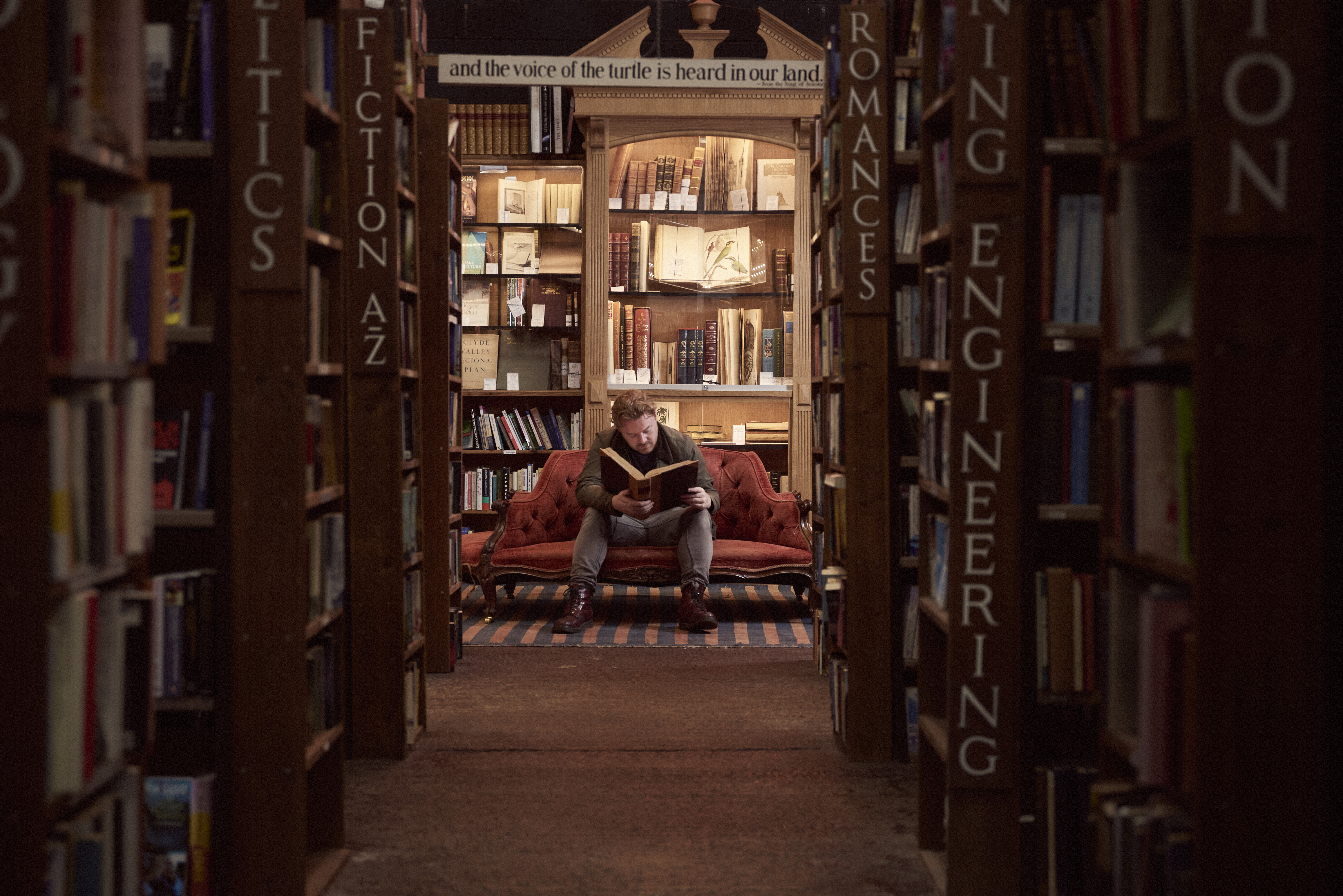 Man in a bookshop, reading a book