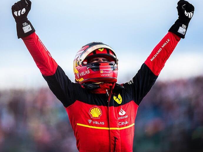 سائق سيارات سباق يرفع ذراعيه في الهواء