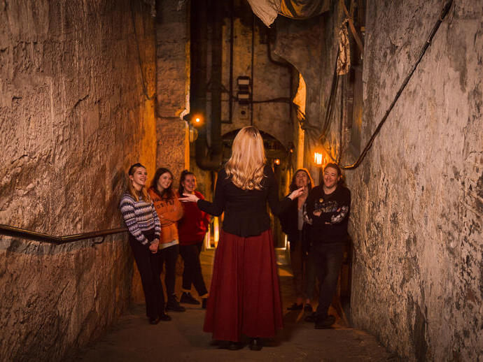 Una guida turistica che conduce un tour attraverso il Real Mary King's Close a Edimburgo, in Scozia