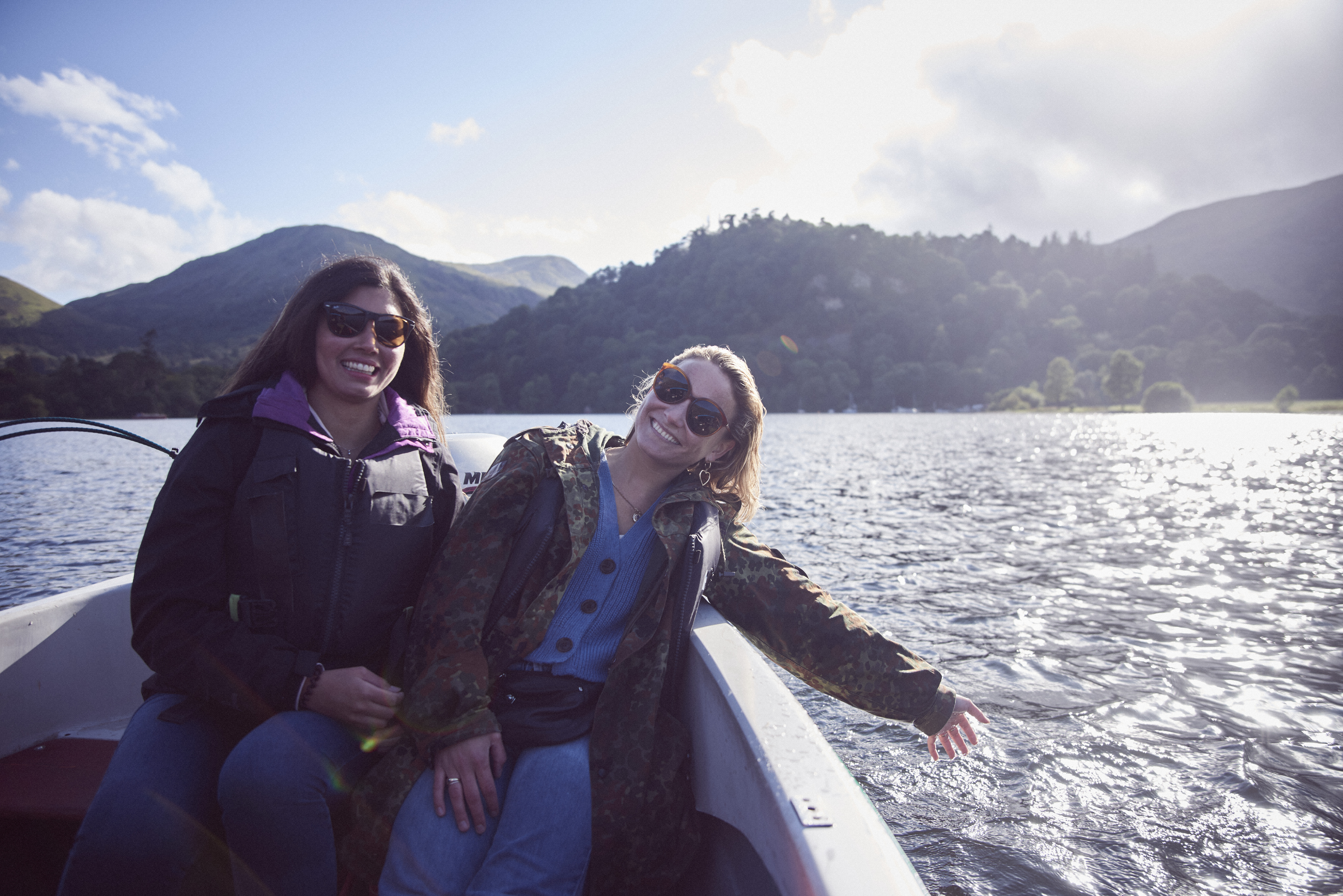 Two women wearing sunglasses on a boat on the lake