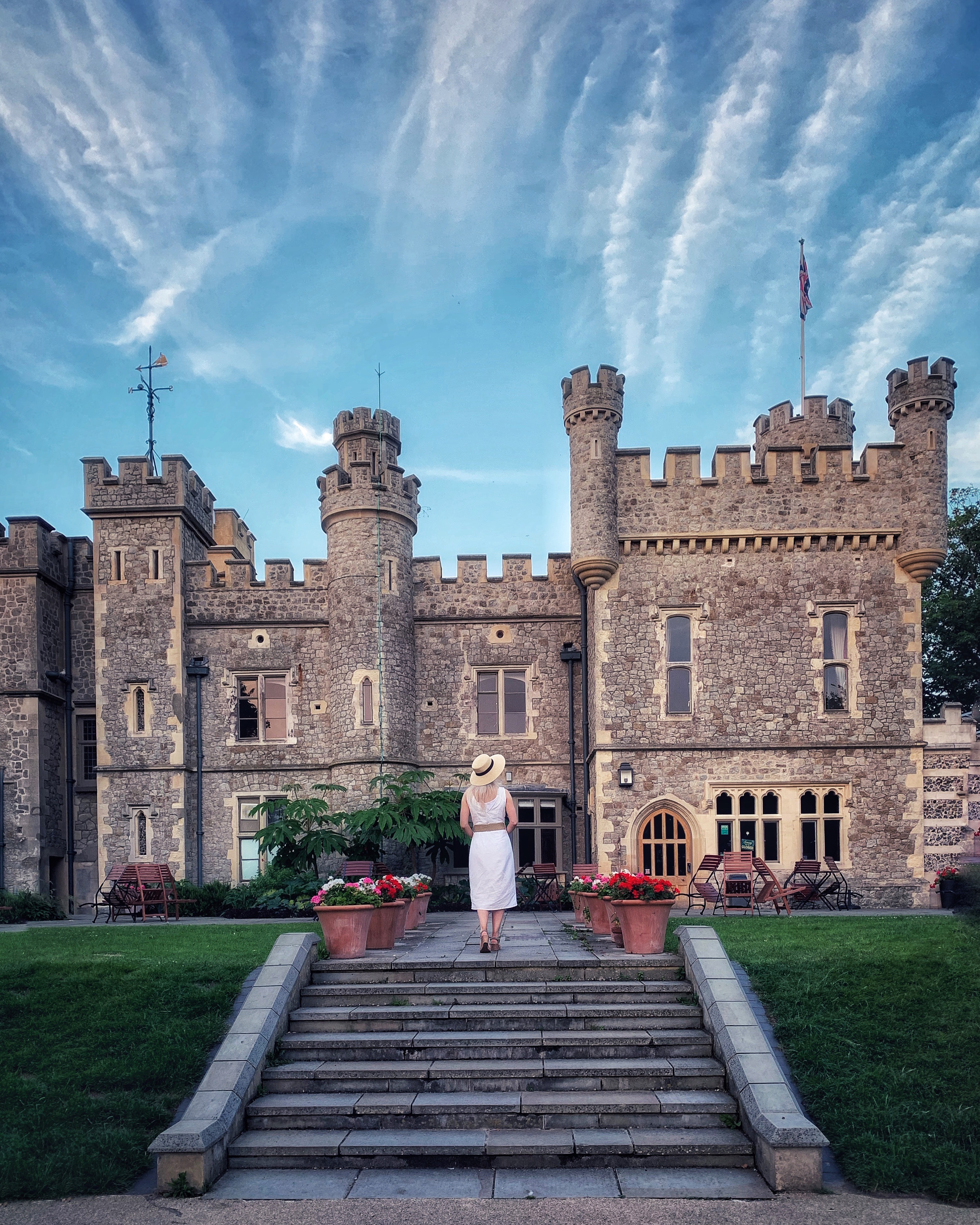Young woman standing on terrace in front of castle