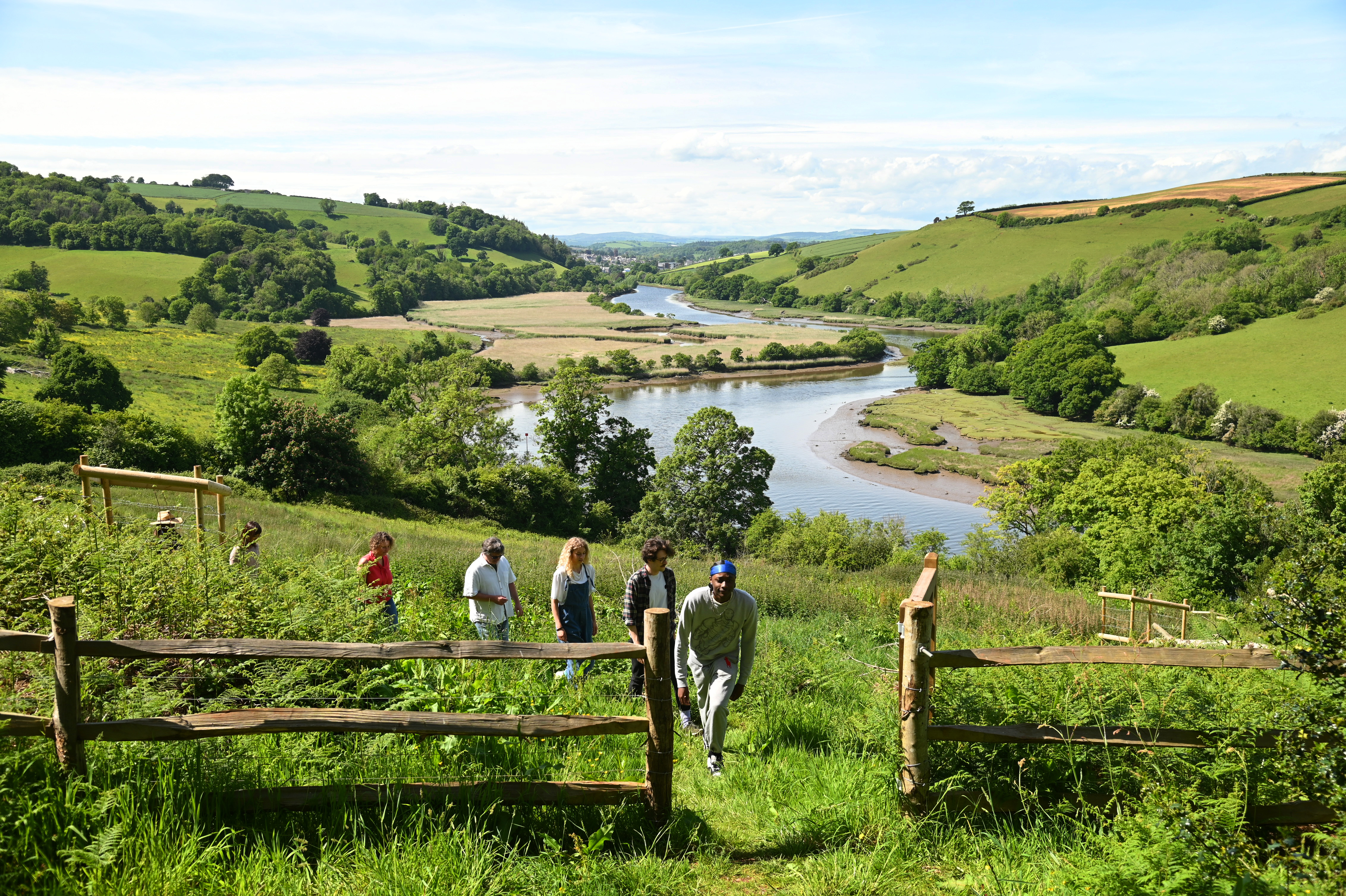 A group of people walking on a hill in the countryside