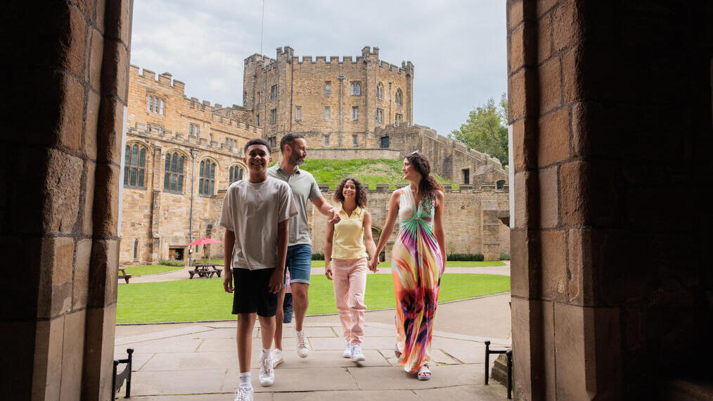 Family walking through an arch in the grounds of a cathedral