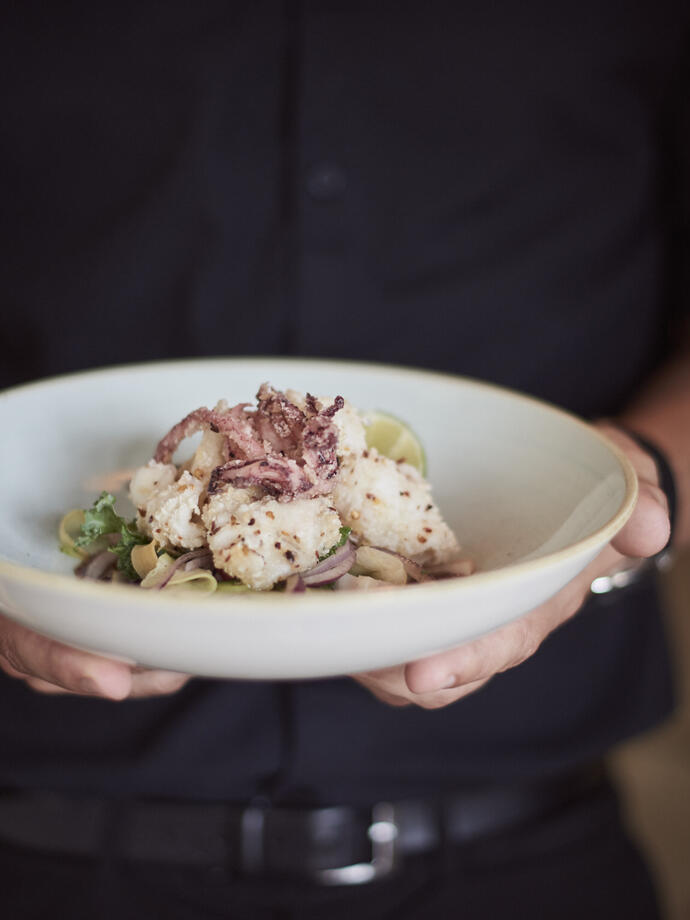 Gros plan d'une personne tenant une assiette avec de la nourriture.