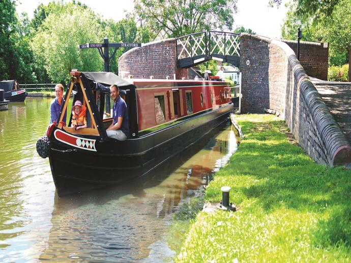 A family riding down a canal on a barge