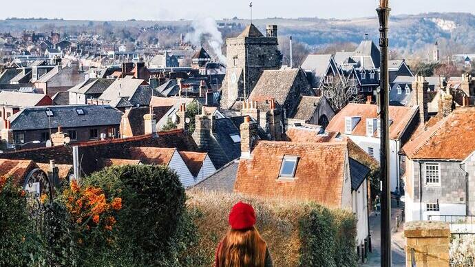Woman looking down a lane to a village below
