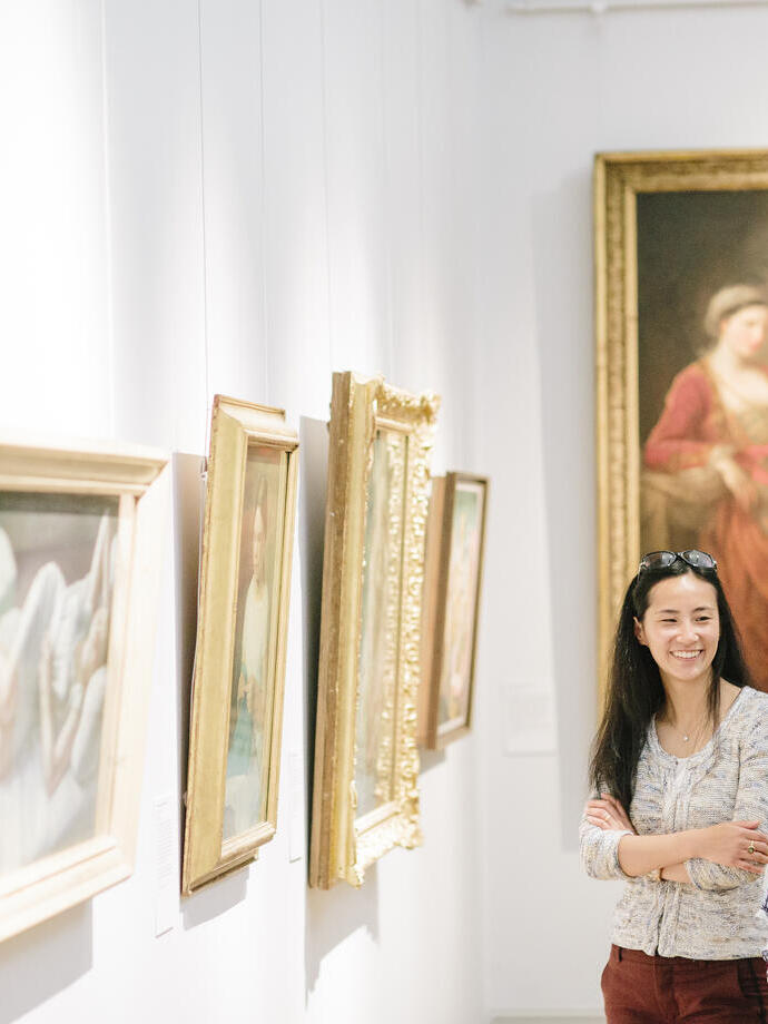 Two women looking at paintings in a gallery