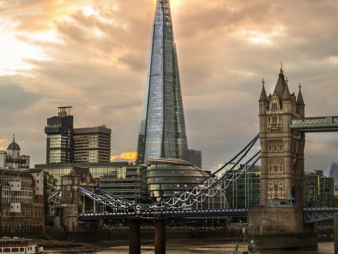 Modern and traditional buildings and bridge looking across a river with a boat in the foreground