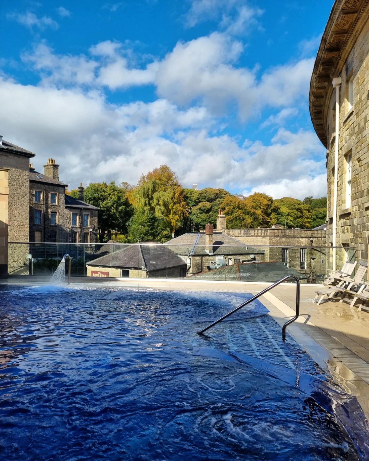 Blick auf das Thermalbad im Freien mit Gebäuden im Hintergrund