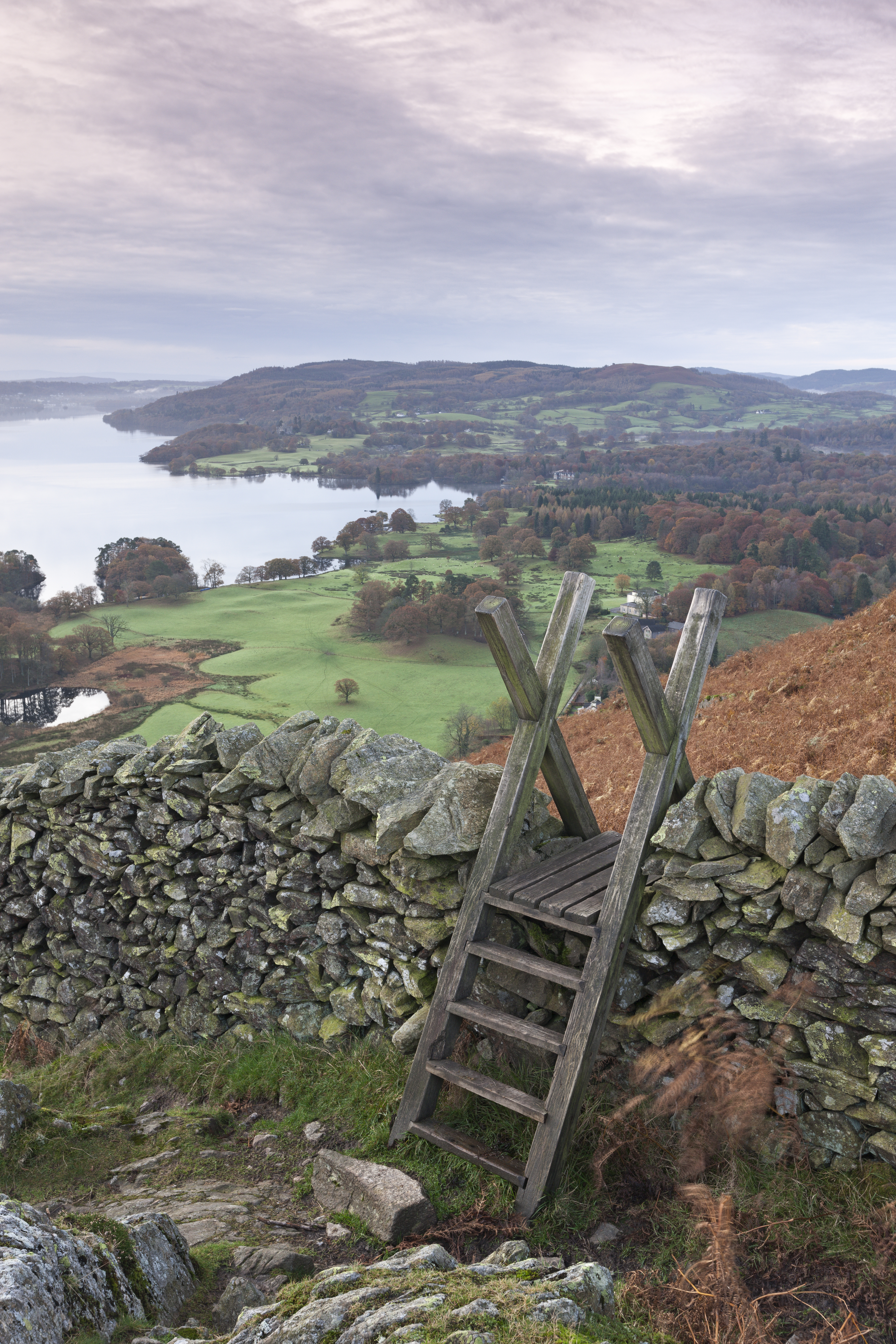 Stile over a drystone wall overlooking landscape of valleys