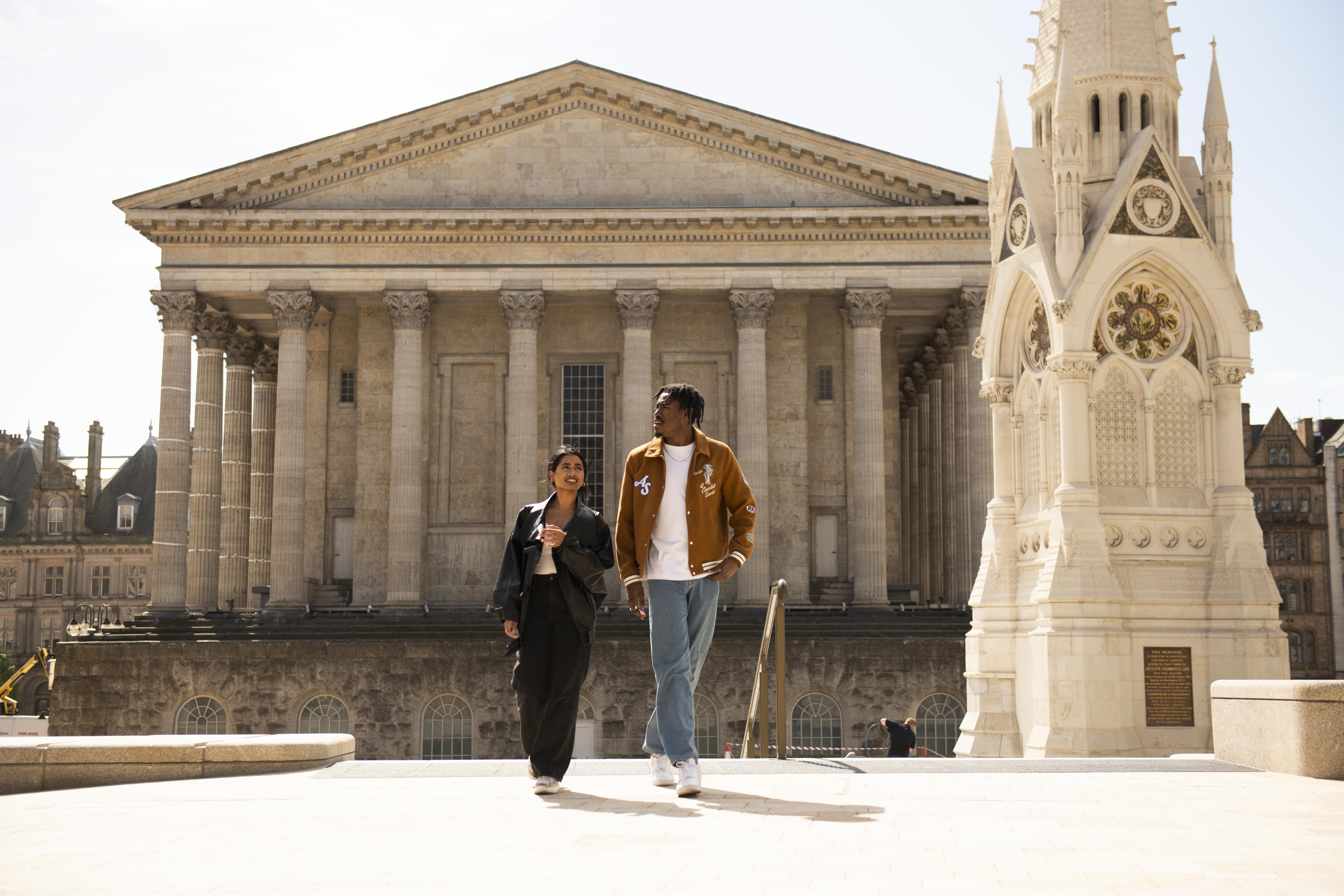 A couple strolling through an ornate English Town Square