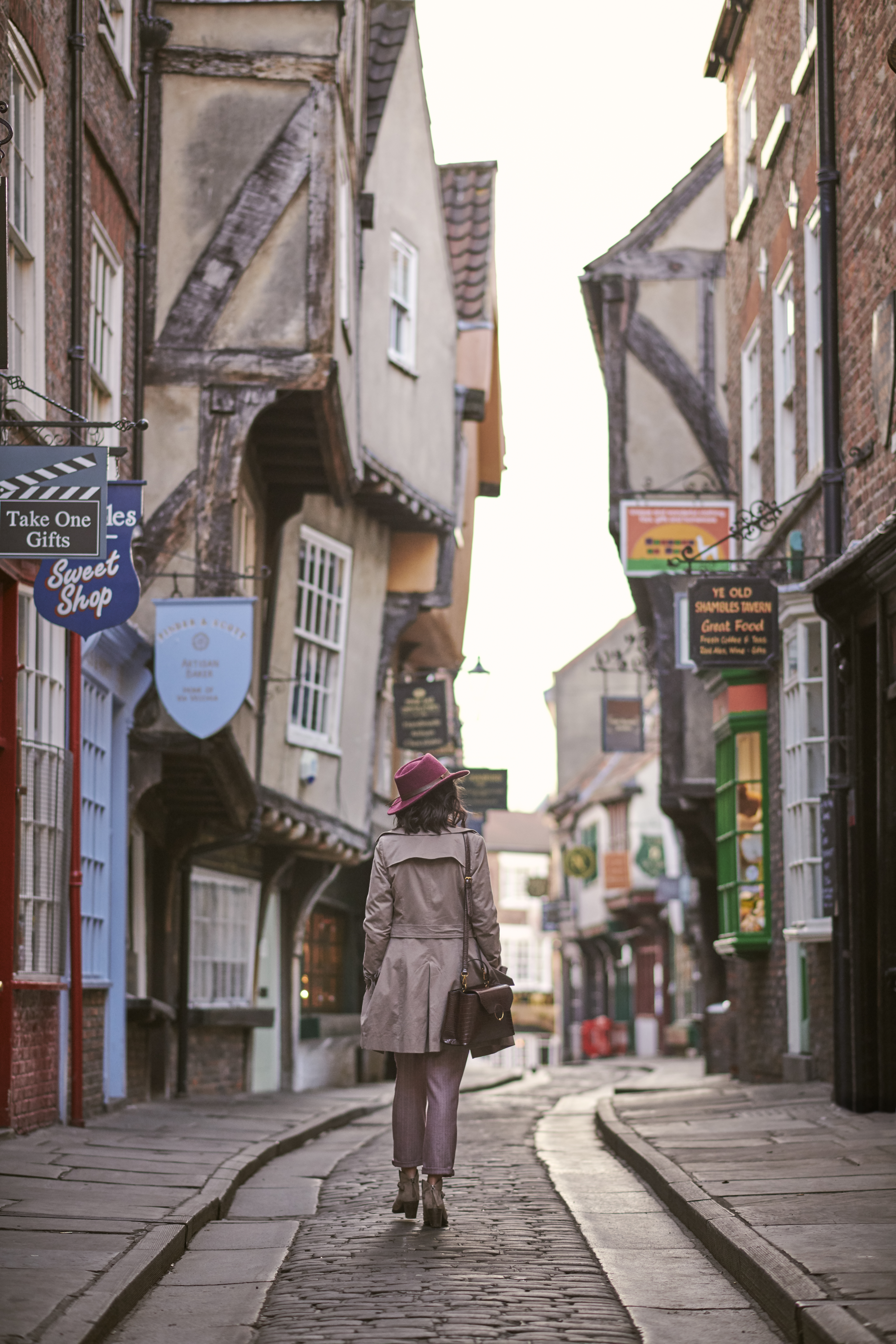 Woman walking through a narrow historic street in a city