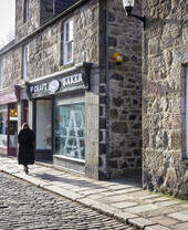People walking along a traditional cobbled British high street.