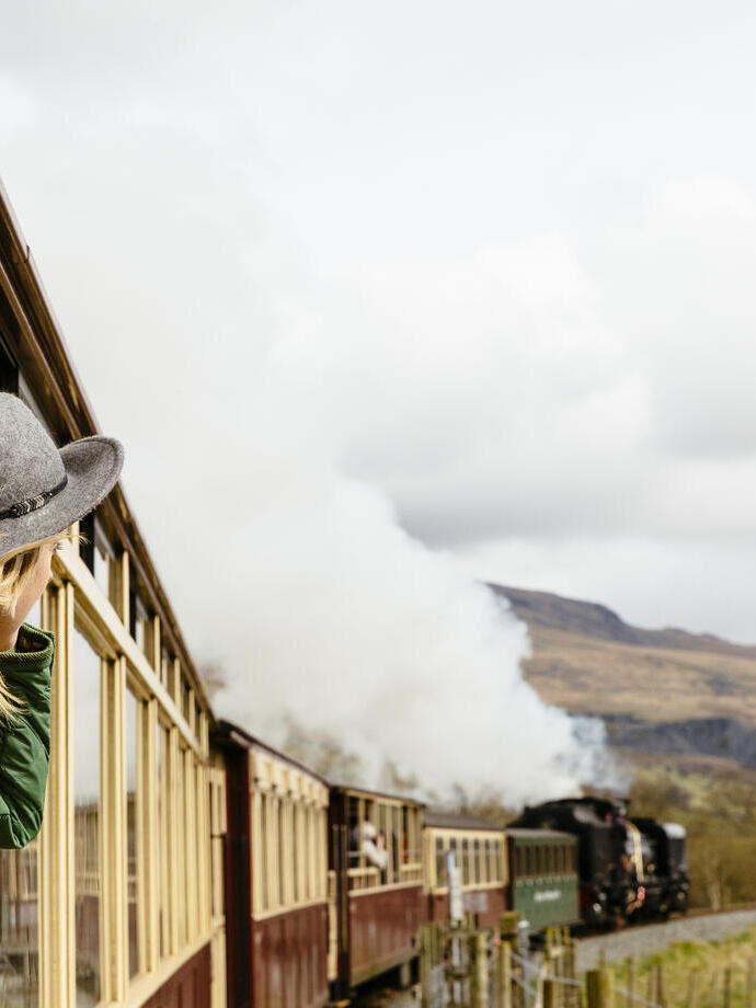 Femme regardant par la fenêtre d'un train traditionnel