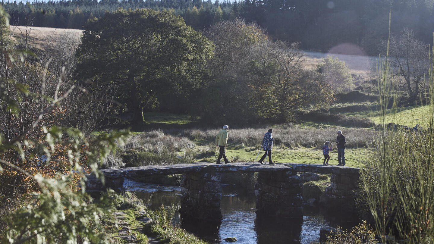 People walking on stone bridge across river