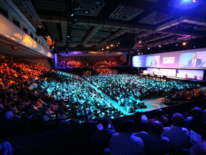 Group of people sitting in an auditorium during a presentation