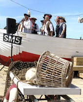 Un groupe de chanteurs en costume devant le Brighton Fishing Museum