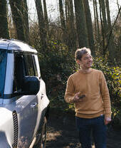 Man standing by a vehicle in a wood
