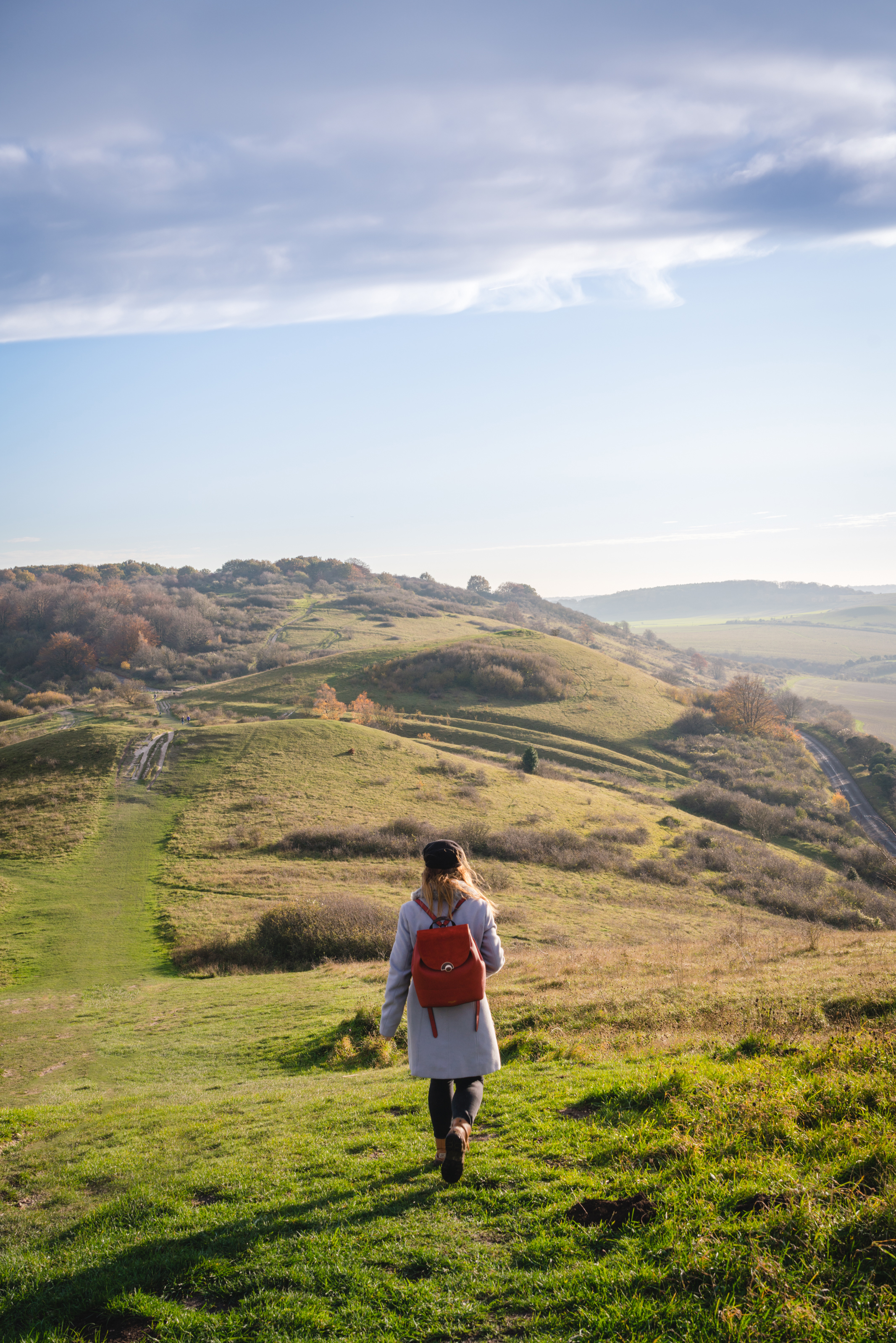 Woman walking a path high up on a ridgeway in the sunshine