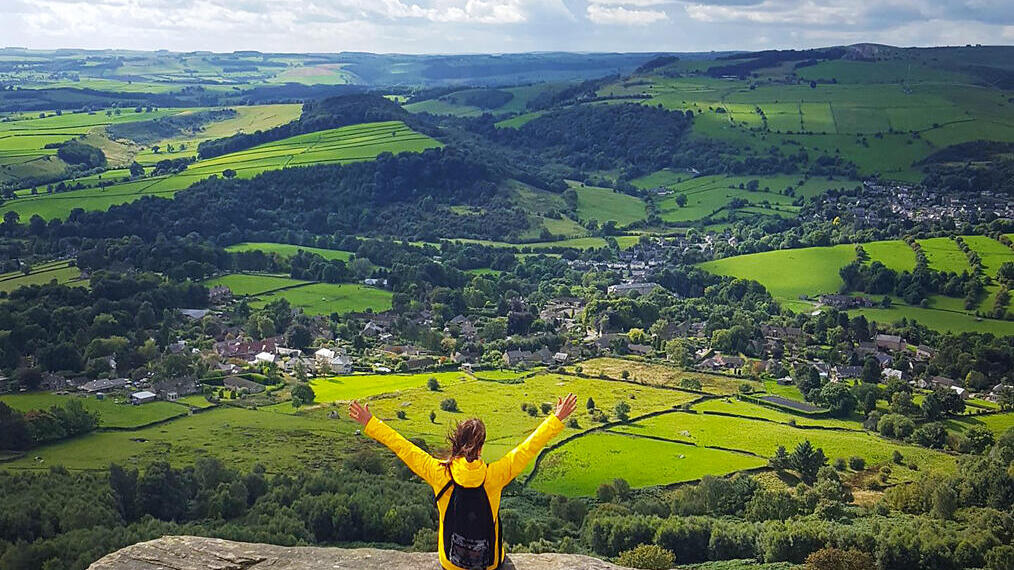 A woman with her arms raised enjoying the view from high