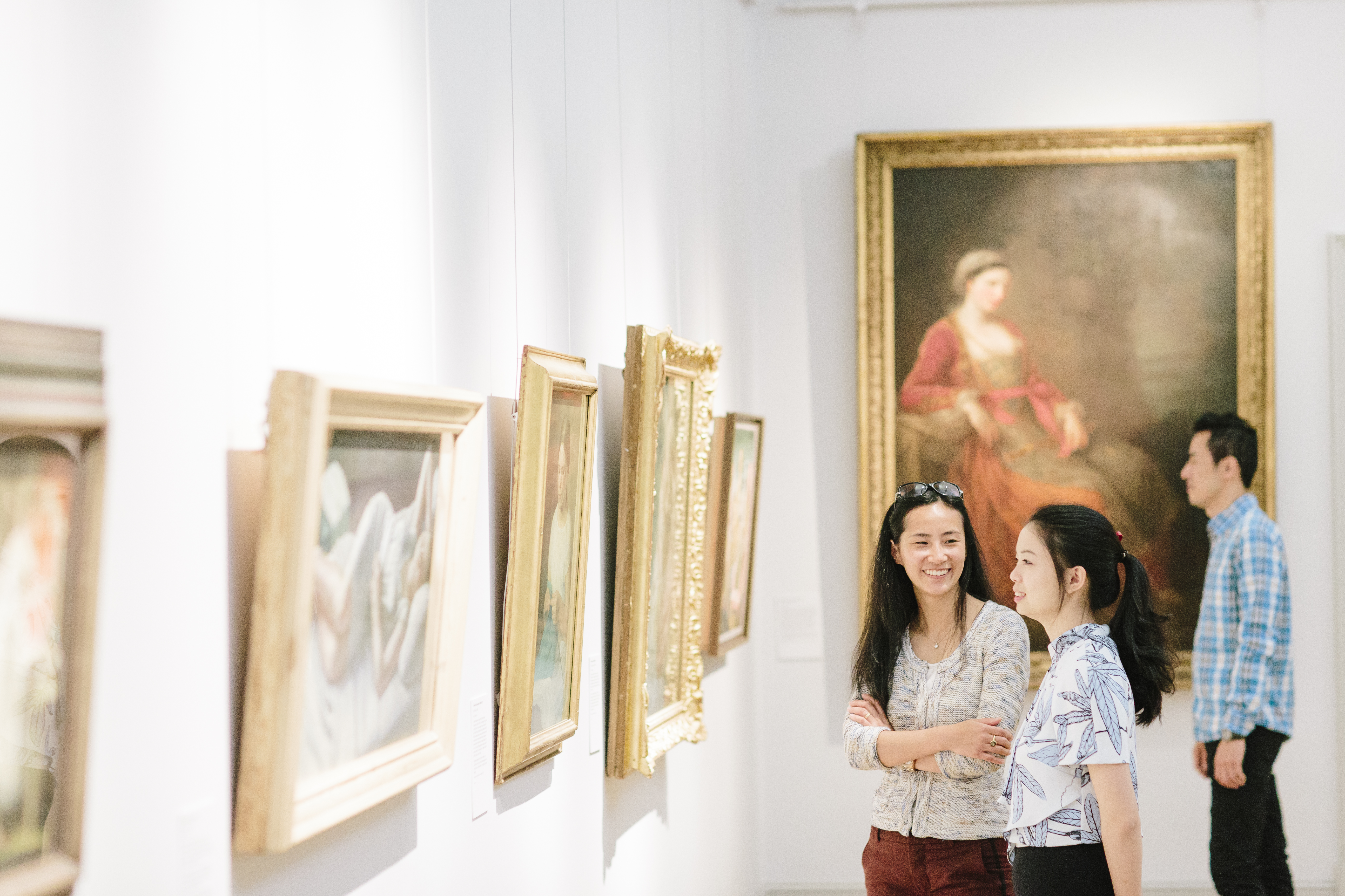 Two women looking at paintings in a gallery