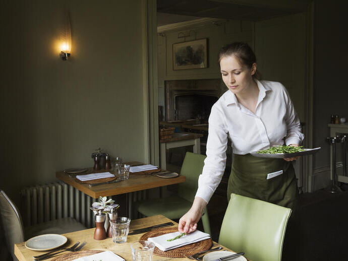 Woman setting a table in a restaurant