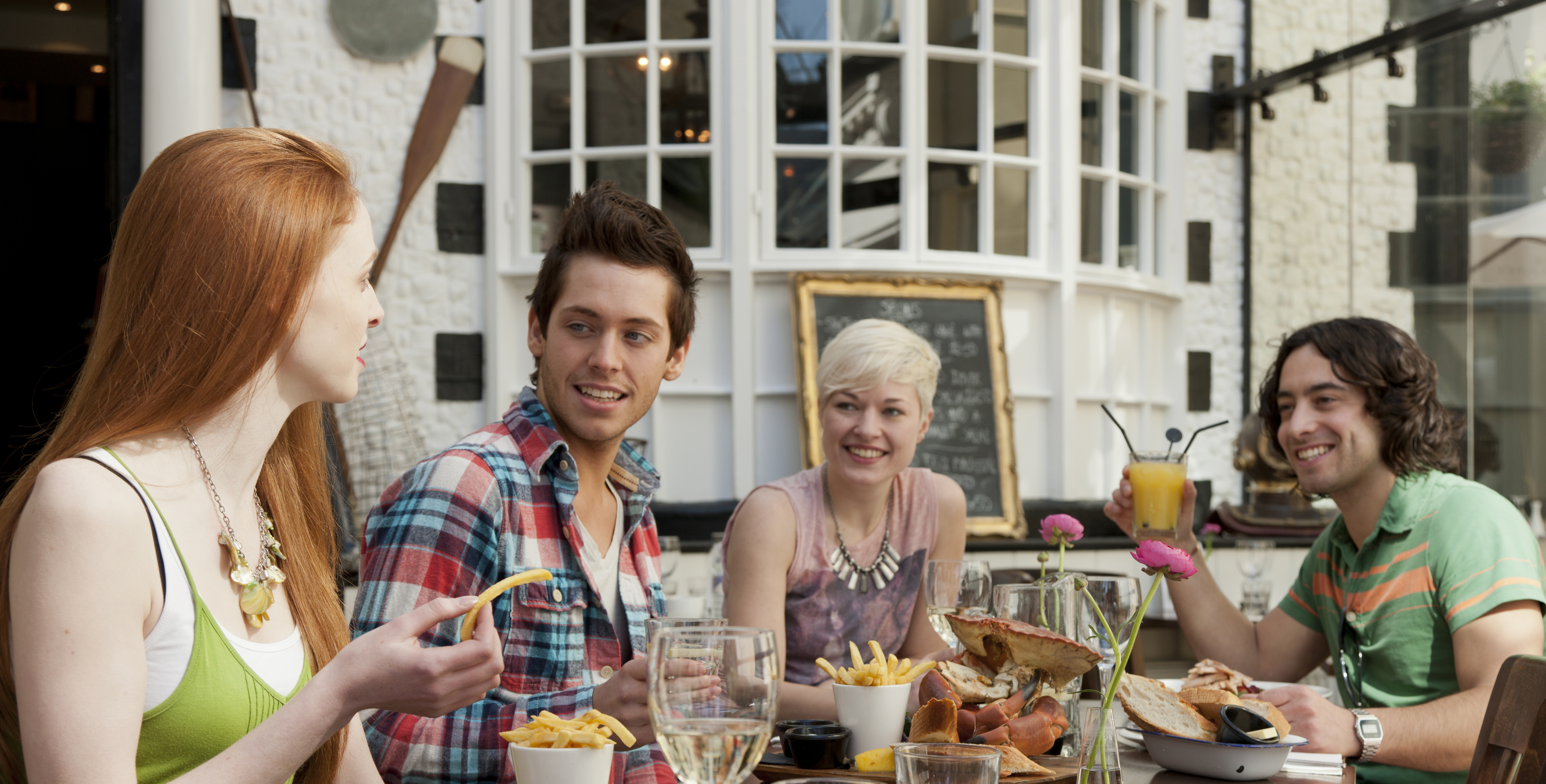 A group of people in a restaurant in Brighton, eating in the open air at Fishy Fishy restaurant.