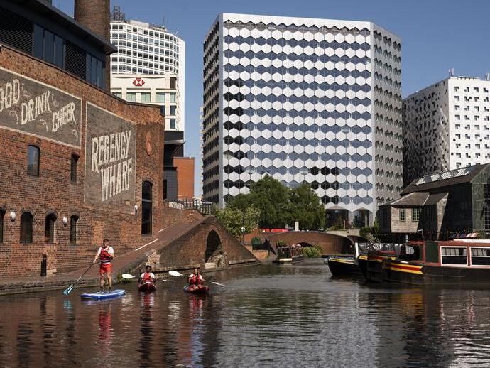 Un groupe de personnes faisant du paddleboard devant le Regency Wharf