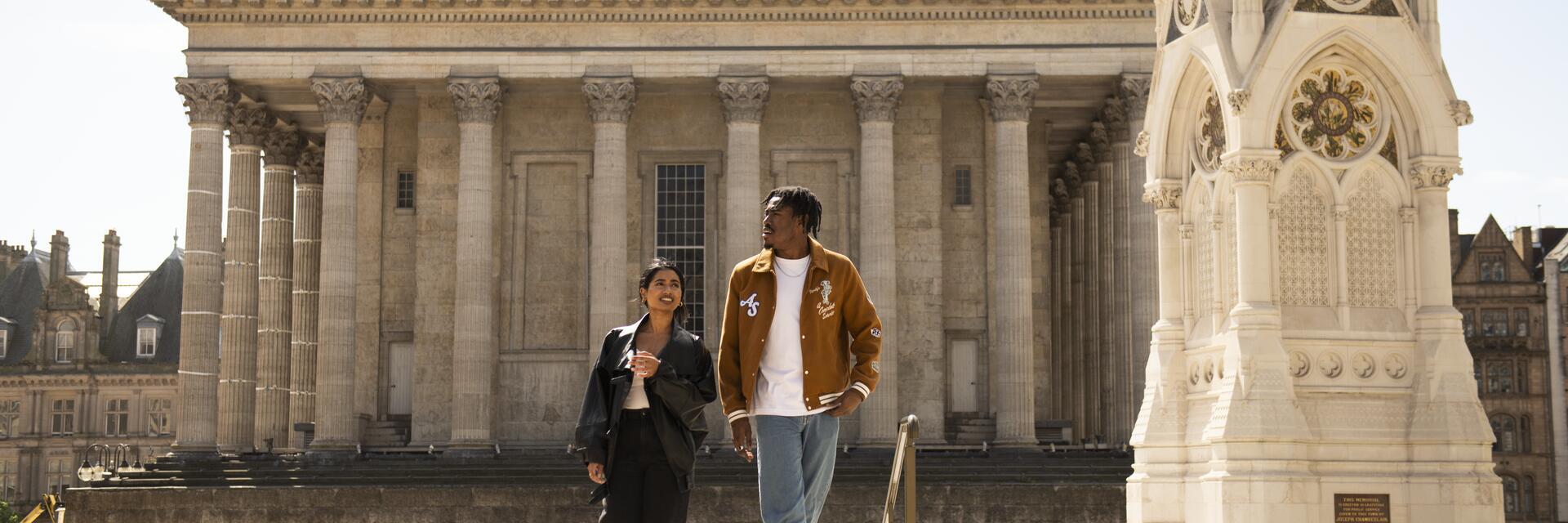A couple strolling through an ornate English Town Square