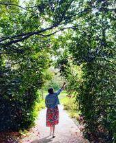 Una mujer con un perro en brazos frente a un lago en Savill Garden, Windsor