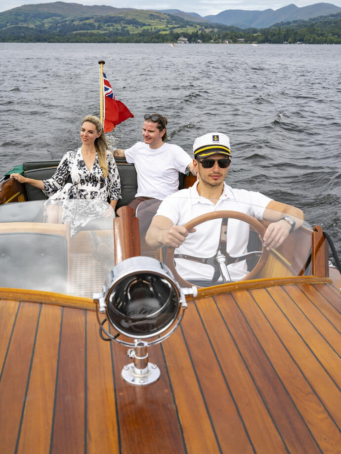 Un homme et une femme sur un bateau conduit par un skipper sur un lac