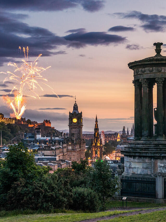 Fuegos artificiales al atardecer en el cielo sobre los monumentos de la ciudad