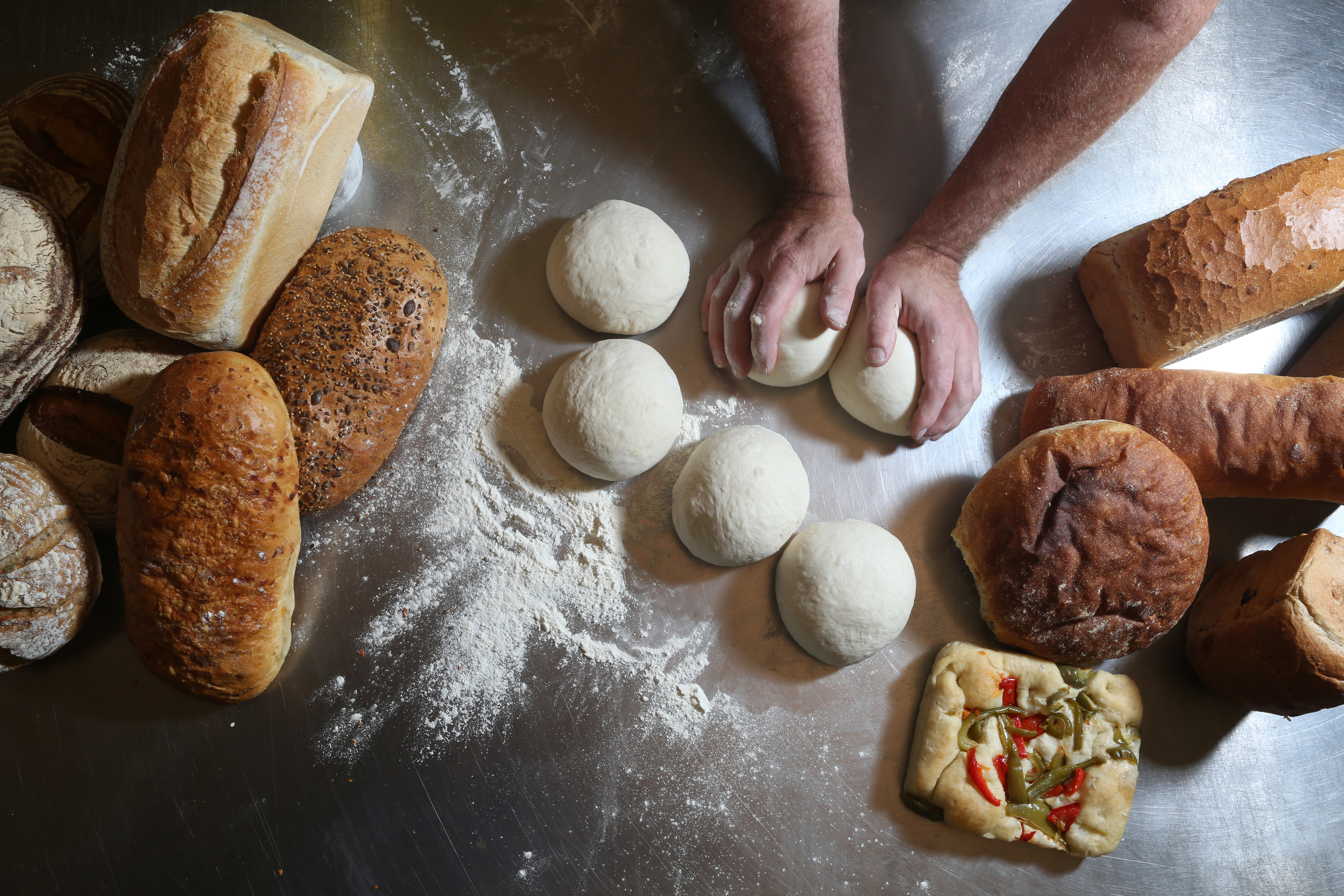 Fresh baked goods being prepared by a baker.