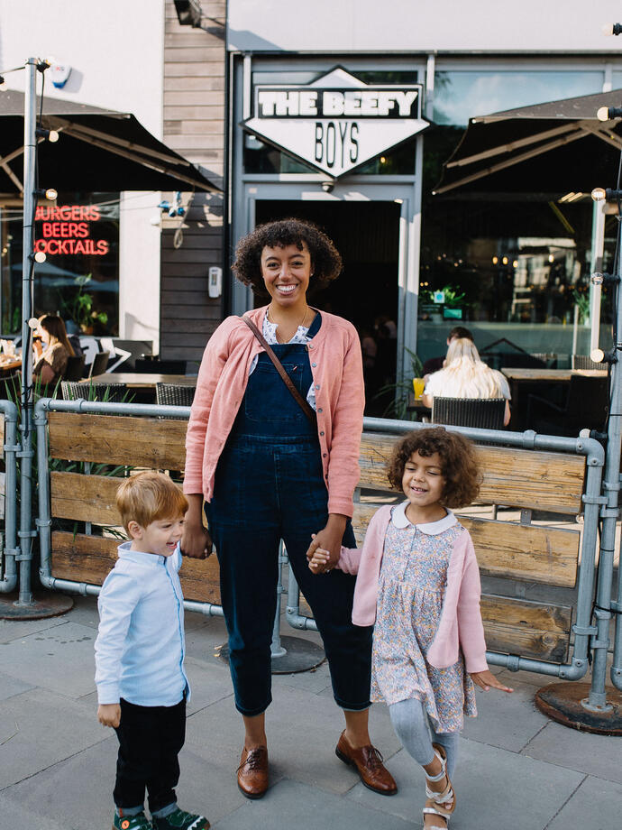 Woman and two children standing outside a restaurant