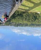 Un groupe pagayant en kayak sous un viaduc avec vue panoramique sur le parc national de Snowdonia/Eryri