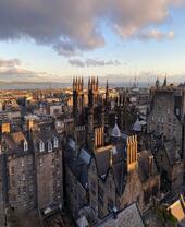 High view of rooftops of Edinburgh with sea beyond as seen from Camera Obscura World of Illusions attraction