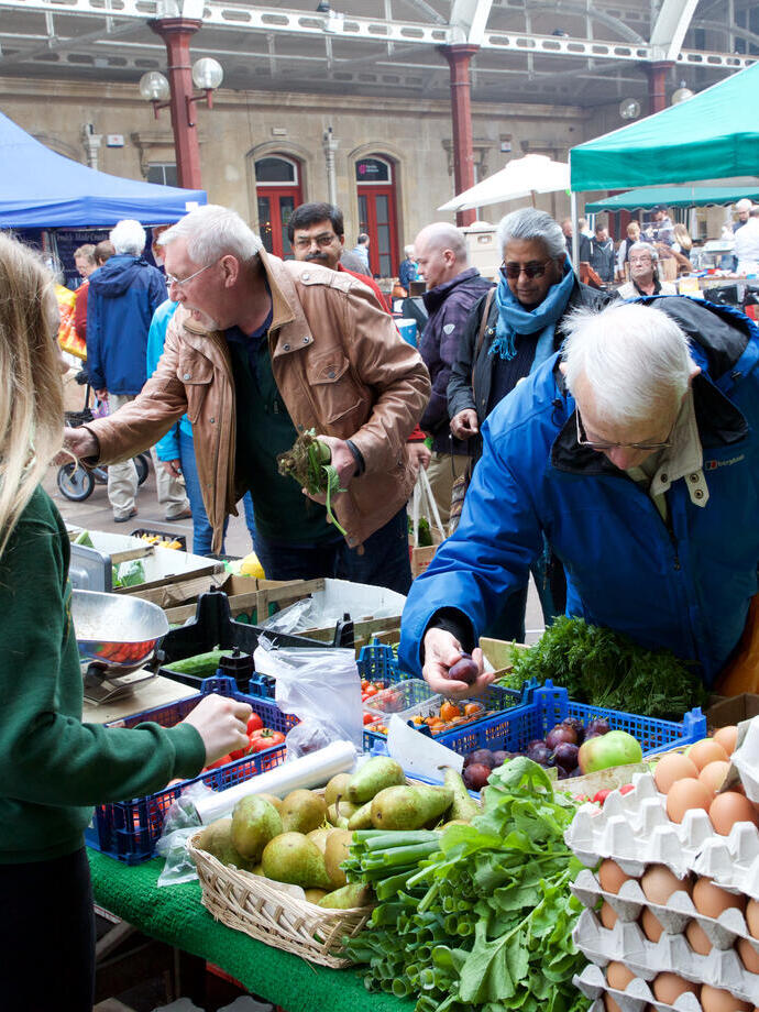 People shopping at an outdoor farmers market.
